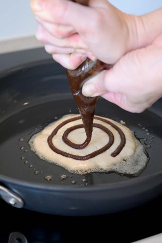 Sprøjte kanelsnegl fyld på pandekage